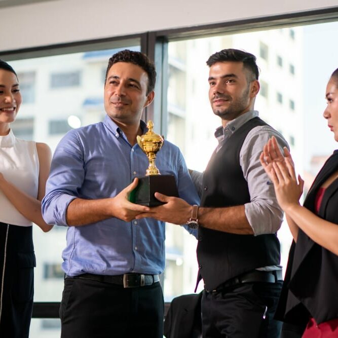 Winning,Business,Team,With,A,Gold,Trophy,Award,.,Successful awarding of employees